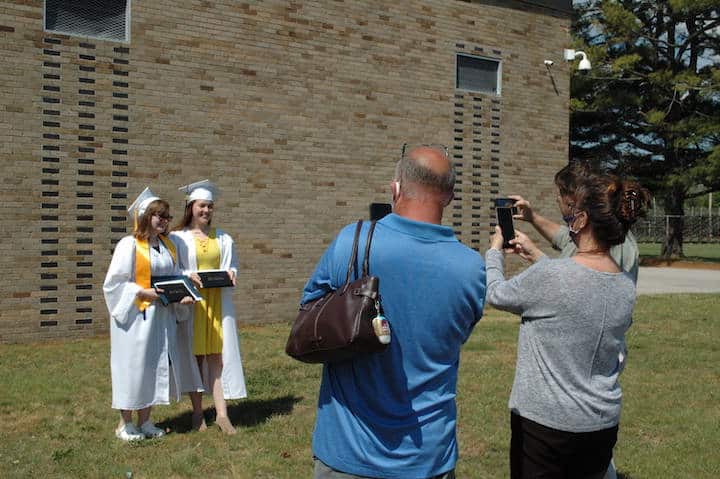 [CREDIT: Rob Borkowski] Pilgrim High 2020 grads Molly Daniels and Sara Corbin pose for pictures after receiving their diplomas June 4, 2020.