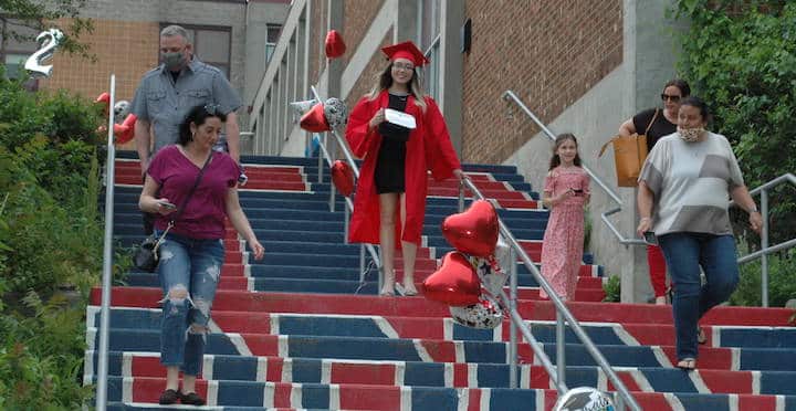 [CREDIT: Rob Borkowski] Tollgate 2020 graduate Megan Devlin descends the stairs at Toll Gate High with her family, diploma in hand.