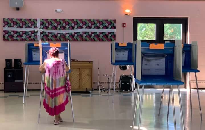 [CREDIT: Rob Borkowski] A woman casts her ballot at Pilgrim Senior Center Tuesday, Sept. 8, 2020. Many cast ballots by emergency and mail in systems,