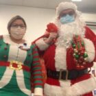 [CREDIT: CNE] Dick Oakley (Santa/pharmacist) and Cindy Santana (Elf/Pharmacy technician) visited the COVID-19 Field Hospital in Cranston to hand out gifts bags filled with get well/holiday cards, crossword puzzles, and decks of playing cards donated from the community.