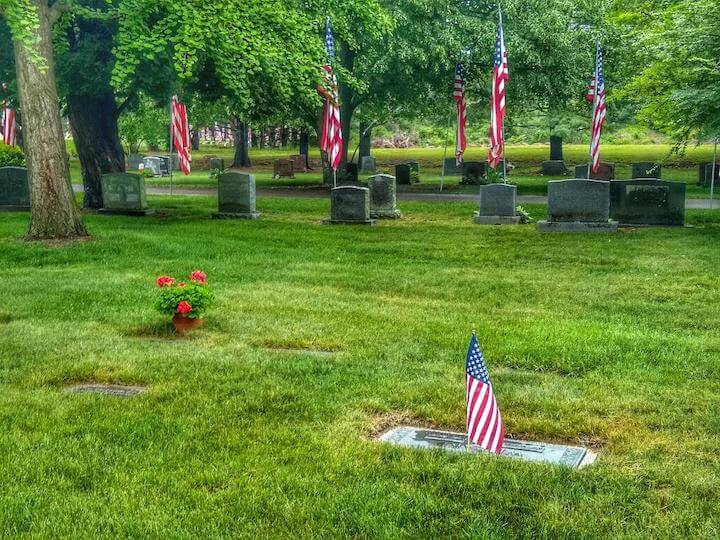 [CREDIT: Lincoln Smith] Pawtuxet Memorial Park graves are bedecked with flowers and flags each Memorial Day.