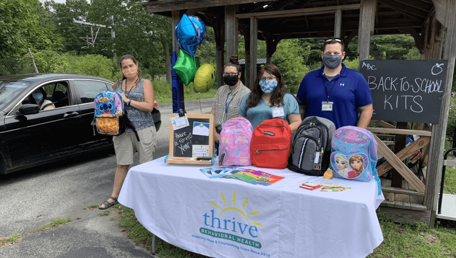 [CREDIT: Thrive] Members of Thrive Behavioral Health’s Youth & Family Services Team hand out backpacks and school supplies to the program’s children and families as part of their Back-To-School Supply Drive.
