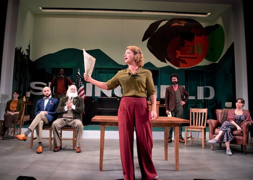 [CREDIT: Peter Goldberg] Nora Eschenheimer (Thea Hovstad) in in Gamm Theater's "A Lie Agreed Upon.' In the background, from left,: Aryn Mello Pryor (Petra Stockman), Jonathan Higginbotham (Peter Stockman), Jomo Peters (Captain Horster), Fred Sullivan Jr. (Aslaksen), Donnla Hughes (Katherine Stockman)  in Gamm Theater's "A Lie Agreed Upon' 