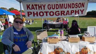 [Courtesy Submission] Kathy Gudmundson, of Cathy Gudmundson Photography, selling her prints at a local art show this summer. She'll be at Shop RI, Crowne Plaza Warwick, on Small Business Saturday.