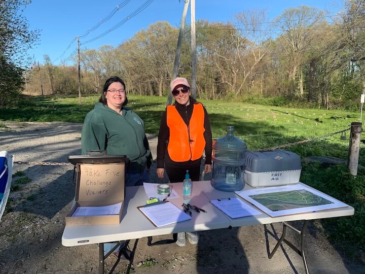 [CREDIT: Rob Borkowski] Pawtuxet River Authority volunteers Alicia Nero and Katie DeGoosh Demarzio greet hikers for a tour through the Howard Conservation Area.