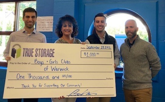 [CREDIT: BGCW] Presenting a $1,000 donation check to the Boys & Girls Club of Warwick's Chief Executive Pfficer Lara D’Antuono are, True Storage team members Josh Gagne, Ben Kfoury and Jacob Fuller.