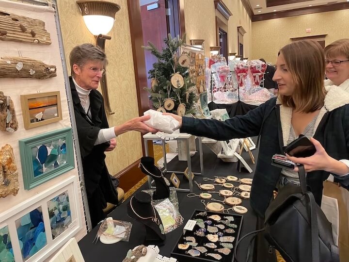 [CREDIT: Rob Borkowski] Nancy Nielsen, owner of Nansea Studios, 5 Division St., East Greenwich, helps out appreciative patrons during Shop RI on Small Business Saturday.