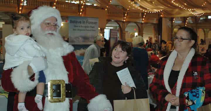 [CREDIT: Rob Borkowski] Santa was one of the many attractions at the RI Author Expo at Rhodes on the Pawtuxet Dec. 7, 2019. From left are Santa, played by Michael Silva, his granddaughter Riley Silva, 9, months, Mary Ann Guerin and Rhoda Silva.