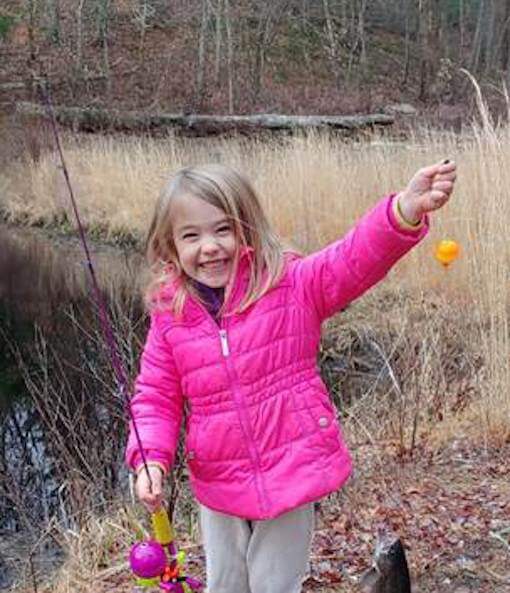 [CREDIT: DEM] An angler shows off her catch during a previous Trout Season Opening Day.