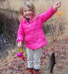 [CREDIT: DEM] An angler shows off her catch during a previous Trout Season Opening Day.