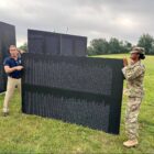 [CREDIT: Mayor Picozzi's Office] Mayor Frank Picozzi helps assemble the Traveling Vietnam Memorial Wall at Rocky Point Park Friday. The replica of the Washington DC monument is open to the public through Sunday, 5 p.m.