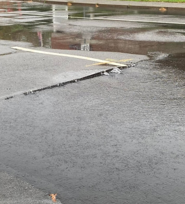 [CREDIT: Mayor Picozzi] A water main break has left Centerville Road shut near the Rte. 95 ramps. Above, a closeup of the road above the broken main shows water from the break flowing from under the pavement.