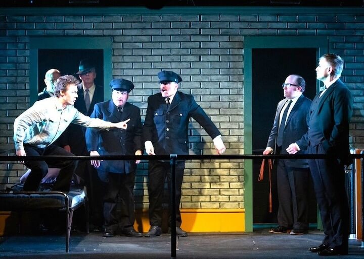 [CREDIT: Cat Laine] A scene from GAMM Theatre's production of HANGMEN. From left, David Ensor (James Hennessey), Jack Clarke (Guard), John Cormier (Guard), Gabriel Graetz (Syd Armfield), Steve Kidd (Harry); In doorway: Steven Liebhauser (Doctor), Bruce Kaye (Governor)