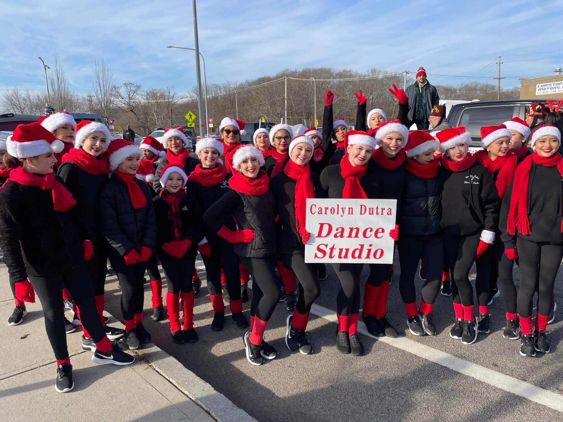 [CREDIT: Rob Borkowski] The Carolyn Sutra Dancers prepare for The Rolling, Strolling Apponaug Winter Festival parade behind City Hall. Sophia Ferraro with the team hold their sign.