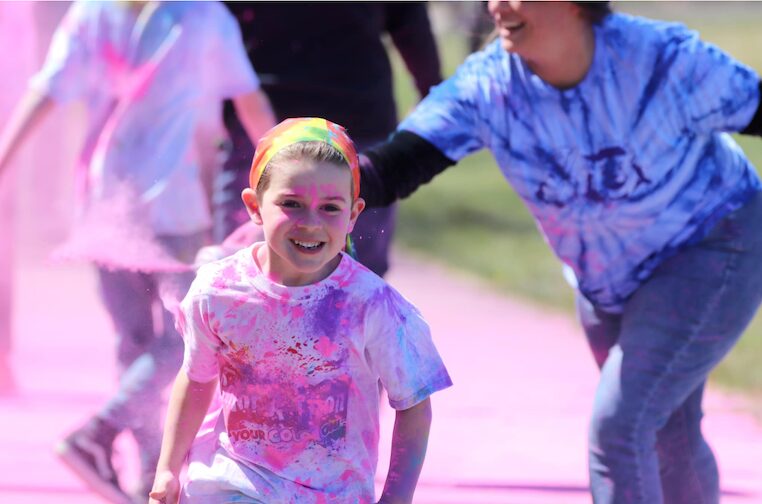 [CREDIT: Roberta Canestrari] First-grader (now second grader) Conor Gill runs during the 2023 Warwick Neck Color-a-thon. Second grade teacher Kirstin Silvia is visible behind him.