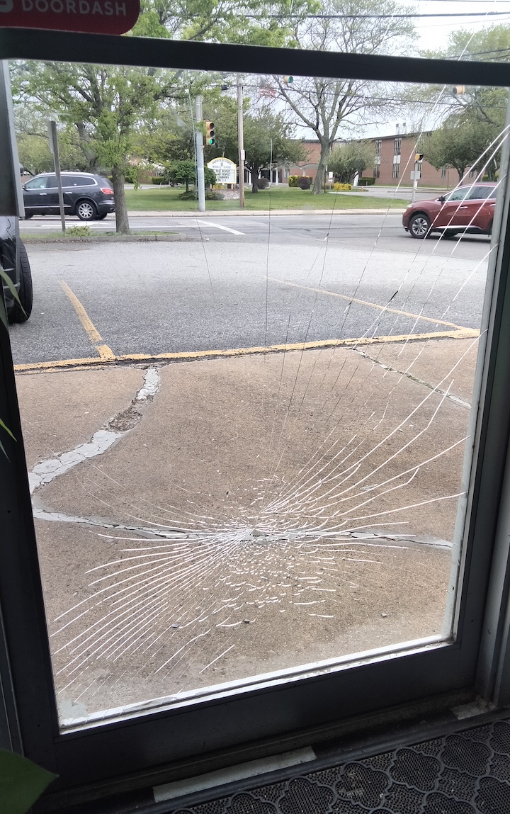[CREDIT: Jennifer Kane] A view of one of two store doors smashed during a West Shore Road vandalism spree early Saturday, May 18, 2024.