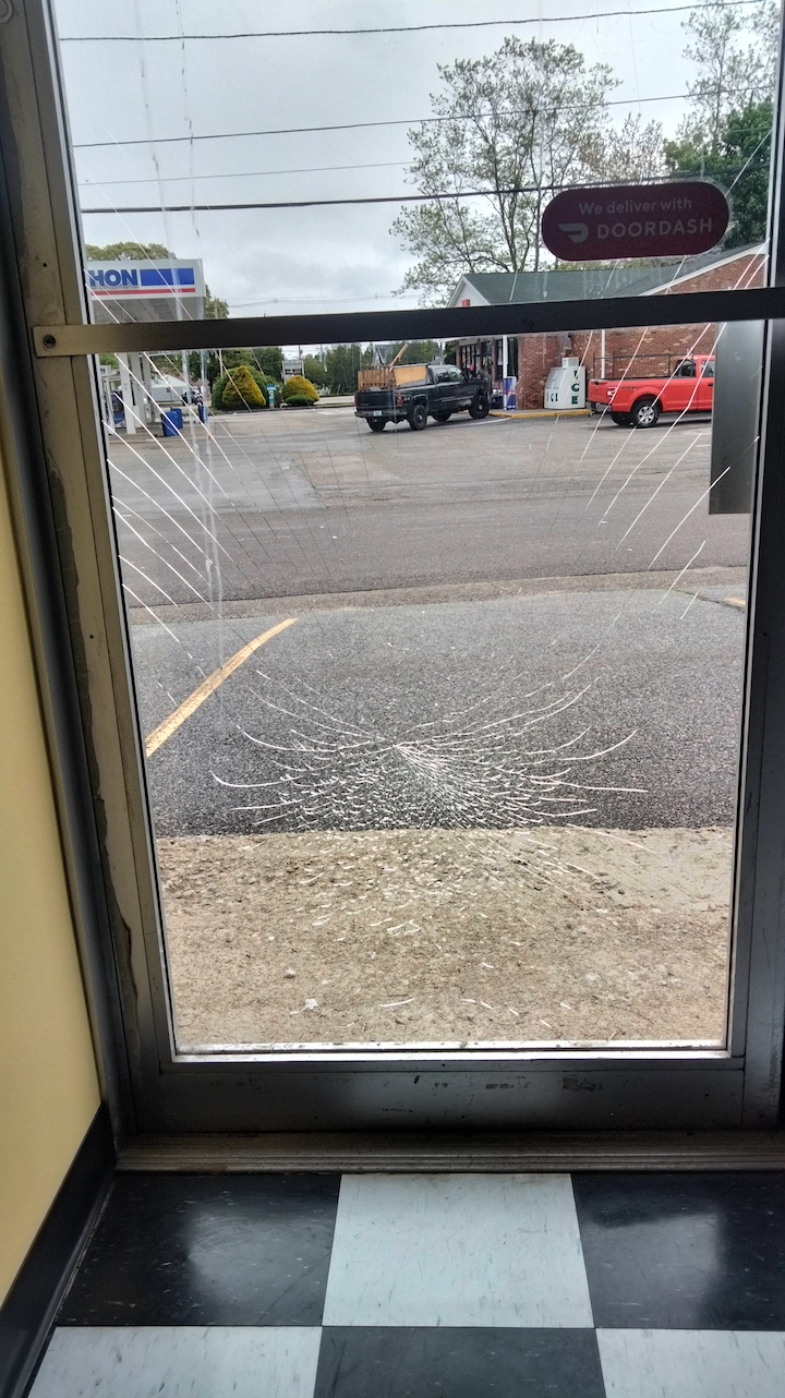 [CREDIT: Jennifer Kane] A view of one of two store doors smashed during a West Shore Road vandalism spree early Saturday, May 18, 2024. 
