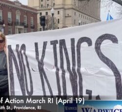 Two Newport, RI women hold a sign reading "No Kings" on the sidewalk outside the State House April 19 during a repeat "Hands Off" protest against the Trump Administration.