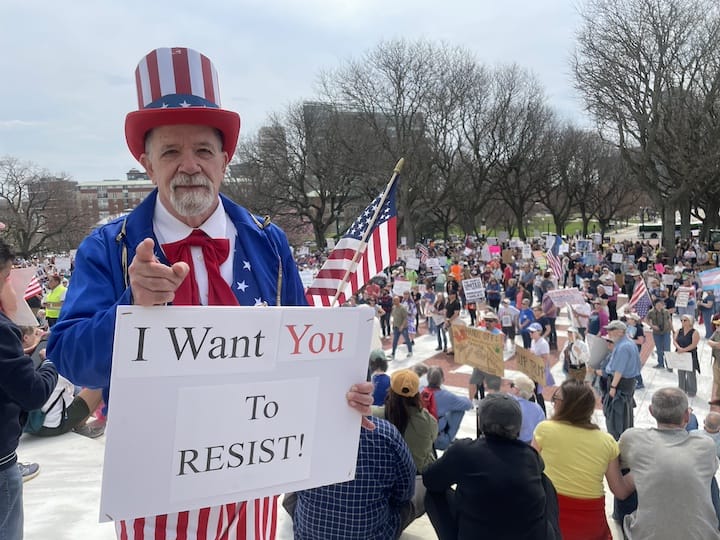 Jim Sulanowski, dressed as Uncle Sam, among thousands of people gathered at the State House April 19 Hands Off protest against the Trump Administration