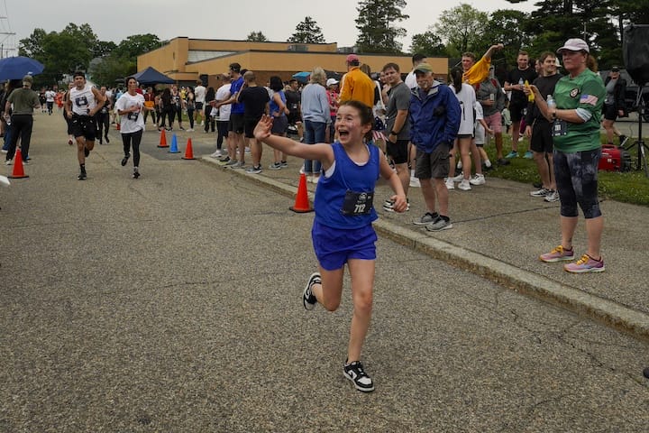 [CREDIT: Laura Paton] One of the hundreds of youth runners, C. Connors of Cranston, can’t hold back her excitement as she crosses the finish line.during the Gaspee Days 5K June 14, 2025.