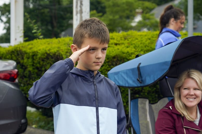 [CREDIT: Laura Paton] Brody Vale of Cumberland salutes, as soldiers as the 2025 Gaspee Days Parade passes by.