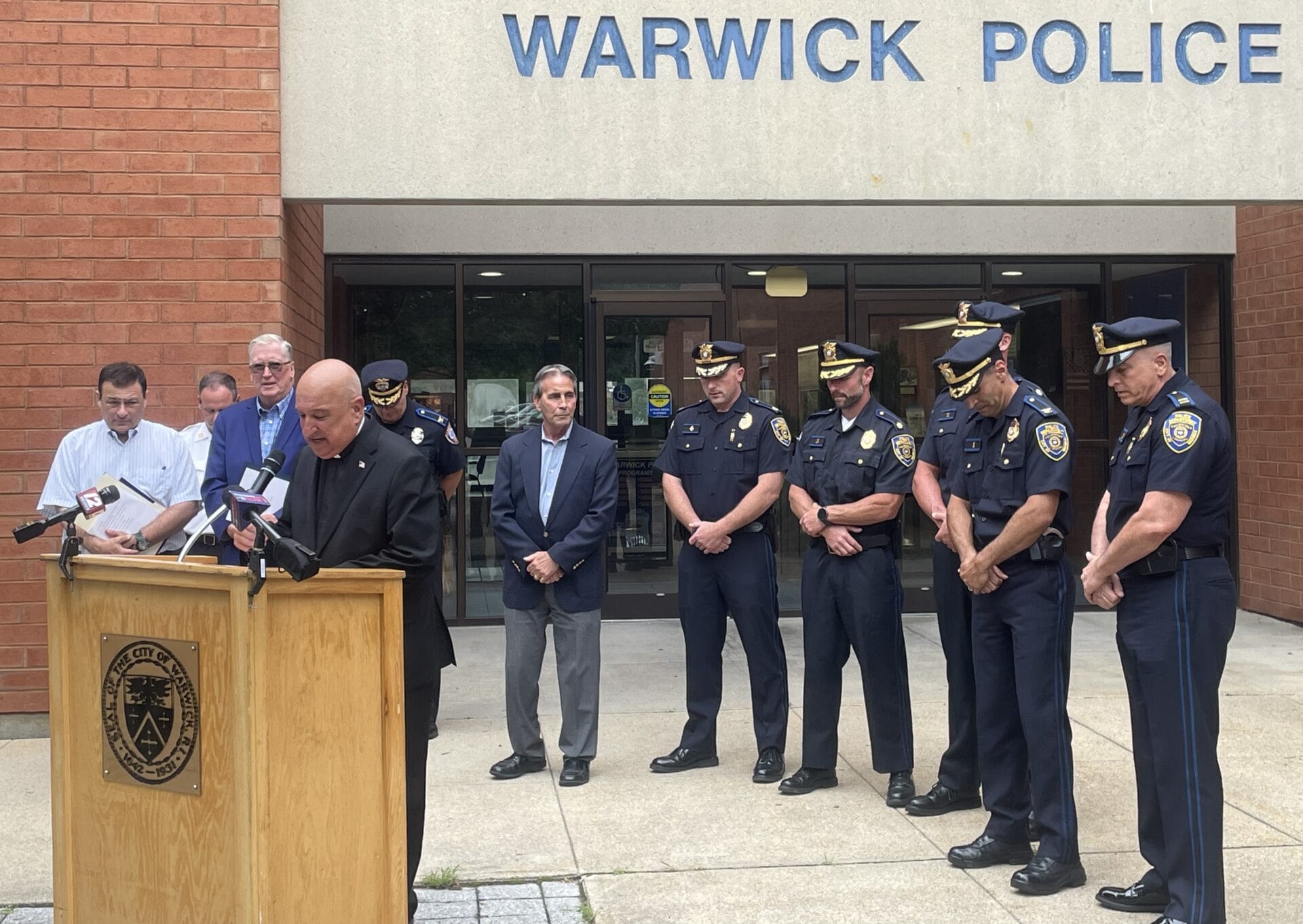 [CREDIT: Rob Borkowski] Rev. Robert L. Marciano leads a prayer asking God to bless WPD Capt. Charles Boisseau and the people he saved from a house fire July 5, 2025. 