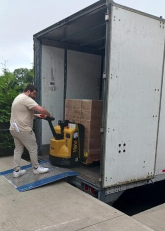 [CREDIT: Lincoln Smith, Photographic Society of RI member] Jordan Hiatt, Westbay Marketplace Supervisor unloading donated food at West Bay Marketplace, 487 Jefferson Blvd., on July 14.