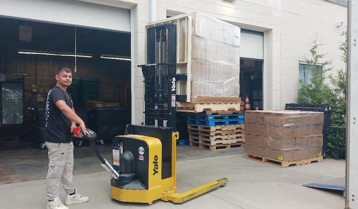 [CREDIT: Lincoln Smith, Photographic Society of RI member] Caden Denton unloading donated food at West Bay Marketplace, 487 Jefferson Blvd., on July 14.