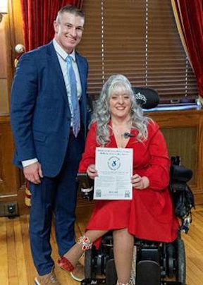 [CREDIT: Legislative Press & Public Information Bureau] Rep. Evan P. Shanley, left, and Tina Guenette, founder & CEO of RAMP (Real Access Motivates Progress), who testified in favor of legislation creating a reporting app for reporting illegal use of mobility parking.